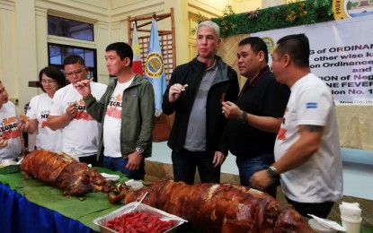 <p><strong>ASF-FREE.</strong> Provincial officials led by Governor Eugenio Jose Lacson have a bite of lechon after declaring Negros Occidental as African swine fever-free province and signing 'The ASF Prevention Ordinance of Negros Occidental' at the Capitol Social Hall in Bacolod City on Tuesday afternoon. The ordinance is scheduled for publication on Wednesday (Nov. 27, 2019) after which its provisions will be enforced starting December 6. <em>(PNA photo by Nanette L. Guadalquiver)</em></p>