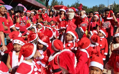 <p><strong>WHERE IS SANTA?</strong> Santa Claus was traditionally former city councilor Narciso Padilla for 45 years but he died last March 3. Here, the late Padilla is seen with young learners dressed as Santa Claus with their parents during the Children's Mardi Gras four years ago. <em>(Photo courtesy of the photo collection of the Padilla family)</em></p>