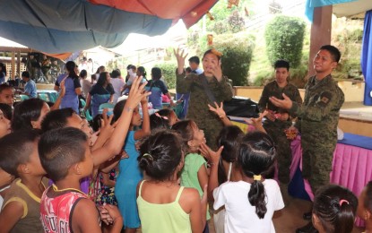 <p><strong>OUTREACH.</strong> Soldiers distribute candies to children during a community support program in Pinabacdao, Samar. The army has incorporated mobile birth registration in its outreach activities in rebel-infested communities in Samar. <em>(Photo courtesy of 46th Infantry Battalion)</em></p>