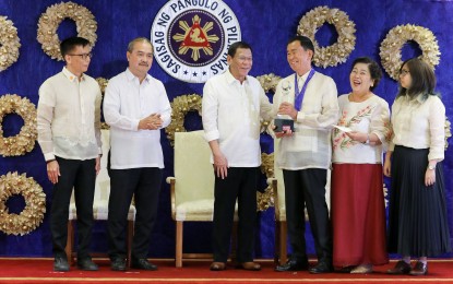 <p><strong>OFW MODEL FAMILY.</strong> President Rodrigo Duterte shares a light moment with one of the awardees of the 2019 Model Overseas Filipino Worker (OFW) Family of the Year Award (MOFYA) during the awarding ceremony at the Malacañan Palace on November 28, 2019. Duterte pledged to meet the needs of overseas Filipino workers by creating more work and livelihood opportunities for them in the country. <em>(Presidential Photo)</em></p>