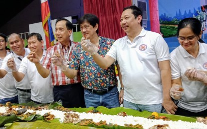 <p><strong>BOODLE FIGHT</strong>. Agriculture Secretary William Dar (fourth from left), ABONO Party-list Rep. Conrado Estrella III (third from right), Samahan Ng Industriya at Agrikultura (SINAG) chairman Rosendo So (second from right) and Rosales Mayor Susan Casareno (far right) pose for a photo as they led the lunch 'boodle fight' in Rosales town Sunday (Dec. 1, 2019) to highlight that Pangasinan and the hog industry in the province is safe from African swine fever. Dar was also in Urdaneta City where a boodle fight was held.  <em>(Photo by Liwayway Yparraguirre)</em></p>