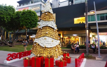 <p><strong>SEASON OF GIVING.</strong> A Christmas tree adorned with gold and white decorations stands at the center of the Bonifacio High Street in Taguig City. This time of the year is also a season of shopping as many Filipinos troop to malls and other establishments to buy gifts for their loved ones. <em>(PNA photo by Lloyd Caliwan)</em></p>