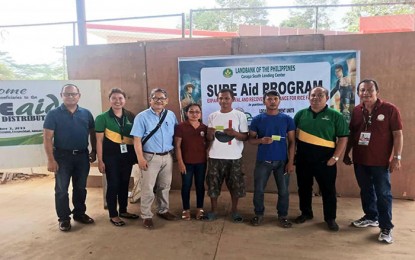 <p><strong>CASH AID.</strong> Department of Agriculture 13 (Caraga) Executive Director Abel James I. Monteagudo (3rd from left) leads the distribution of cash assistance to 360 rice farmers in Prosperidad, Agusan del Sur on Tuesday (Dec. 3, 2019). The assistance was under the Expanded Survival and Recovery Assistance for Rice Farmers (SURE Aid) Program of the Agricultural Credit Policy Council of the DA, in coordination with the Land Bank of the Philippines.<em> (Photo courtesy of DA-13 Information Office)</em></p>