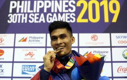 <p><strong>GOLDEN SMILE</strong>. Philippines’ bet Dexter Bolambao displays the gold medal he won in the arnis competition of the 30th Southeast Asian Games on December 2, 2019. The host country dominated the Filipino sport, winning 14 of the 20 gold medals at stake. (<em><strong>Phisgoc photo)</strong></em></p>