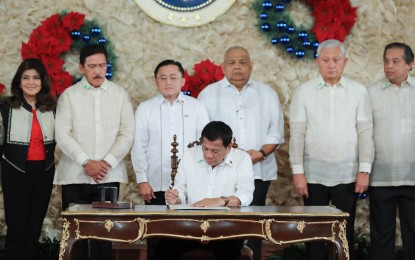 <p><strong>NEW LAW.</strong> President Rodrigo Duterte signs the Malasakit Center Act during a ceremony at the Malacañan Palace on December 3, 2019. Earlier, Senator Christopher "Bong" Go, the law's main author, said the Malasakit Center law is meant to complement the Universal Health Care Act. (Republic Act 1223). <em>(Presidential Photo)</em></p>