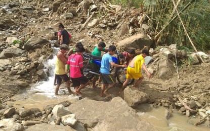 <p><strong>LANDSLIDE.</strong> A group of men carries a motorcycle after a major landslide blocked a road in Northern Samar. The Provincial Disaster Risk Reduction and Management Council recommended on Tuesday (Dec. 3, 2019) the declaration of state of calamity as Typhoon Tisoy left a trail of destruction in the province. <em>(Photo from FB page of Citizen's Disaster Response Center)</em></p>
