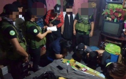 <p><strong>DISMANTLED.</strong> Agents of the Philippine Drug Enforcement Agency in the Bangsamoro Autonomous Region in Muslim Mindanao (PDEA-BARMM) conduct an inventory of the illegal drugs seized inside a suspected drug den in Cotabato City on Wednesday (Dec. 4, 2019). Five suspects (handcuffed), including the alleged drug den operator, were arrested during the operation. <em>(Photo courtesy of PDEA-BARMM)</em></p>