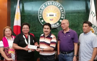 <p><strong>ADDITIONAL FUND</strong>. Mayor Evelio Leonardia (center) receives the PHP5-million additional assistance of the Dangerous Drugs Board (DDB) from chief cashier Melanie Castillo (second from left) for the construction of the first phase of the PHP35-million Bacolod City Drug Treatment and Rehabilitation Center, during their meeting at the Bacolod Government Center on Monday (Dec. 9, 2019). The turnover was witnessed by DDB accountant Ludivira Jarin (left), Vice Mayor El Cid Familiaran (second from right) and Councilor Al Victor Espino. <em>(PNA photo by Nanette L. Guadalquiver)</em></p>
