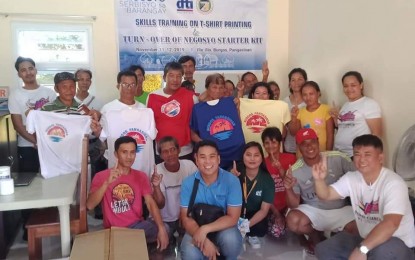<p><strong>NEGOSYO SERBISYO SA BARANGAY.</strong> Residents of Burgos town in Pangasinan pose for a photo with their trainers from Net At Las Printing Shop on Nov. 11, 2019. The skills training on souvenir making (t-shirt printing) under the Negosyo Serbisyo sa Barangay of the Department of Trade and Industry is in line with the booming tourism industry in the town. (<em>Photo courtesy of DTI-Pangasinan)</em></p>