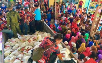 <p><strong>RELIEF DISTRIBUTION.</strong> Workers from the provincial disaster management office of Maguindanao hand out relief packs to over 3,000 displaced families in at least seven conflict-affected villages of Shariff Aguak town on Sunday (Dec. 8, 2019). The families fled their homes after the military launched an all-out offensive against the Islamic State-linked Bangsamoro Islamic Freedom Fighters in the peripheries of Shariff Aguak, Datu Saudi Ampatuan, Mamasapano, and Shariff Saydona Mustapha municipalities on Nov. 24, 2019. <em>(Photo courtesy of Maguindanao PDDRMO)</em></p>