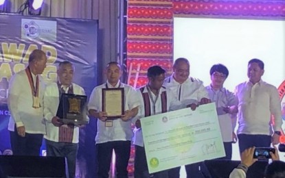 <p><strong>DISASTER READY.</strong> Officials from La Trinidad in Benguet, led by Mayor Romeo Salda and Vice Mayor Roderick Awingan (4th and 5th from left), receive the award from Defense Secretary Delfin Lorenzana during the 2019 Kalasag awards-municipal category at the Philippine International Convention Center in Pasay City on December 6, 2019. La Trinidad got the award for the second consecutive year. <em>(Photo courtesy of Francis Martin/PIA)</em></p>