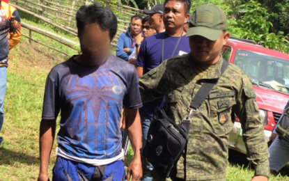 <p><strong>TIMELY SURRENDER.</strong> A soldier accompanies NPA rebel Paquito Mamites (in blue shirt) to a site where North Cotabato Governor Nancy Catamco waits for his surrender in Barangay Don Panaca, Magpet, North Cotabato on Thursday (Dec. 12, 2019). He says he surrendered to the government in his desire to be with his family this Christmas time. <em>(Photo courtesy of North Cotabato PIO)</em></p>