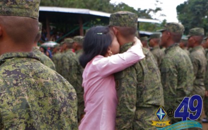 <p style="text-align: left;"><strong>CONGRATULATORY KISS</strong>. A newly inducted Army soldier is kissed and embraced by his significant other during the graduation ceremony for the Basic Military Training and Jungle Warfare Mountain Operations Course Saturday (Dec. 14, 2019). A total of 234 new soldiers participated in the ceremony held inside Camp Osito Bahian, Malaybalay City, Bukidnon. <em>(Photo courtesy of 4th Infantry Division, Philippine Army)</em></p>