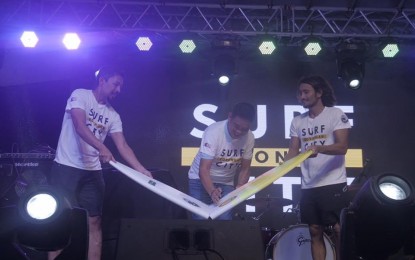 <p><strong>SURFING TILT.</strong> Surfriders Club Eastern Samar president Rupert Ambil (left), Borongan City Mayor Jose Ivan Dayan Agda (center), and Philippine Surfing Championship Tour president Luke Landrigan (right) lead the ceremonial breaking of surfboard for the opening of Surfing in the City in Borongan City, Eastern Samar Sunday (Dec. 14, 2019). It is the first national competition that promotes the city’s long coastline situated within the commercial district as a venue for the surfing event. <em>(Photo courtesy of Surf in the City)</em></p>