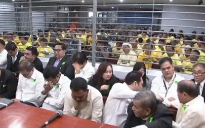 <p><strong>JUSTICE SERVED.</strong> The legal counsels (foreground) and the accused in the Maguindanao massacre case await for the verdict at the Camp Bagong Diwa in Taguig City on Dec. 19, 2019. The court found eight members of the Ampatuan clan and 20 others guilty for 57 counts of murder and meted them with the penalty of reclusion perpetua (up to 40 years imprisonment) without parole. <em>(Screengrab from PTV-4)</em></p>
