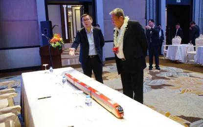 <p><strong>NO SOLICITATION.</strong> Department of Transportation Secretary Arthur Tugade (right) inspects a scale model of a Philippine National Railways train. The DOTr on Tuesday warned against individuals or groups soliciting investments for the Mindanao Railway Project, a project funded through an official development assistance from China. <em>(File photo)</em></p>