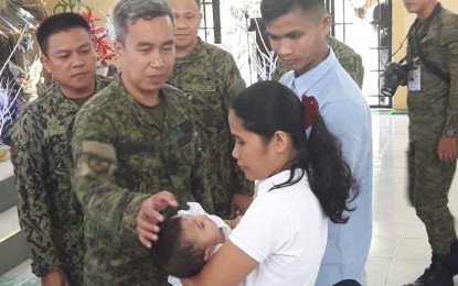 <p><strong>RETURN TO THE FOLD OF LAW. </strong>Lt. Col. Jose Mari Torrenueva II, commander of the Army's 91st Infantry Battalion, touches the forehead of the daughter of the former members of the New People's Army (NPA), during the baptismal ceremony at the Philippine Army’s 7th Infantry Division Headquarters, Fort Magsaysay, Palayan City, Nueva Ecija on Friday (December 20, 2019). Torrenueva is one of the godparents of the first child of the former rebels.<em> (Photo by Jason de Asis)</em></p>