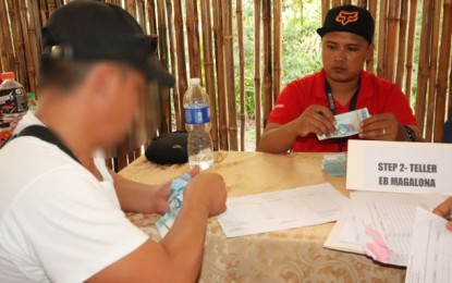 <p><strong>GOV’T AID.</strong> A profiled member of the Kapatiran, formerly known as the Rebolusyonaryong Partido ng Manggagawa-Pilipinas/Revolutionary Proletarian Army/Alex Boncayao Brigade, receives his livelihood grant from the government through the Department of Social Welfare and Development in rites held in Talisay City, Negros Occidental on Friday (Dec. 20, 2019). The activity was led by Secretary Carlito Galvez Jr. of the Office of the Presidential Adviser on Peace Process. <em>(Photo courtesy of 303rd Infantry Brigade, Philippine Army)</em></p>
