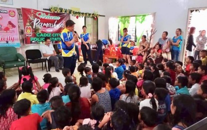 <p><strong>PARTY WITH KIDS</strong>. Lt. Col. Robert Mansueto, chief of the Cadiz City Police Station in Negros Occidental, joins the children of Barangay Andres Bonifacio for a Christmas party and gift giving on Dec. 21, 2019. The outreach is dubbed “Project TEAM (Together Everyone Accomplishes More) Cadiz”. <em>(Photo courtesy of the Cadiz City Police Station PCR)</em></p>