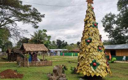 <p><strong>ATTRACTION.</strong> A six-meter-tall Christmas tree made of dried marang fruit leaves and sprayed with metallic gold paint stands inside the headquarters of the Army's 4th Mechanized Infantry Battalion in Baloi, Lanao del Norte. Some 700 dried marang fruit leaves were used in the body of the tree. <em>(Photo by Divina M. Suson)</em></p>