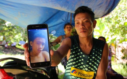 <p><strong>MY BROTHER IS GONE</strong>. Roberto Cabachete showed to the Philippine News Agency an old photo of his brother Bertoldo Cabatchete, Jr. (Junjun) whose remains were exhumed by government forces in Carangalan, Nueva Ecija. Junjun, known as “LJ” in the New People’s Army (NPA) died of pneumonia in December of 2018. A former rebel who surrendered in November this year told authorities about his death and the area where he was buried. <em>(PNA photo by Alexander Lopez)</em></p>