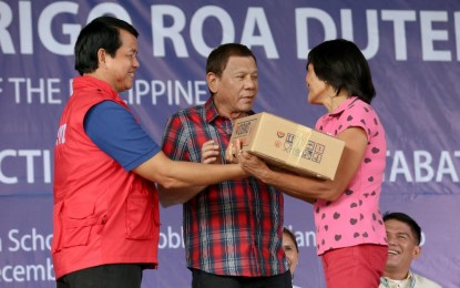 <p><strong>QUAKES-HIT AREAS.</strong> President Rodrigo R. Duterte leads the distribution of family food packs during his visit to the earthquake victims at the M'lang National High School in Cotabato on Monday (Dec. 30, 2019). Assisting the President is Social Welfare and Development Secretary Rolando Bautista. <em>(Presidential photo of Albert Alcain)</em></p>