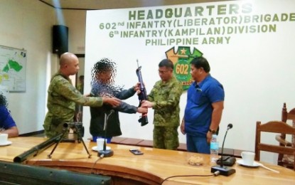 <p><strong>SURRENDERED.</strong> One of five members of an armed lawless group operating in Maguindanao province hands over an M16 rifle to Brig. Gen. Roberto Capulong, commander of the Army’s 602nd Brigade, during surrender rites held in Camp Lucero, Barangay Nasapian, Carmen, North Cotabato on Friday (Jan. 3, 2020). The lawless group, led by a certain Commander Kinis Biya, also yielded a homemade shotgun and a rocket-propelled grenade launcher. <em>(Photo courtesy of 602Bde)</em></p>