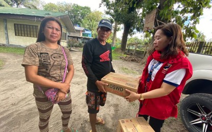 <p><strong>AID TO SLAIN OFW'S KIN.</strong> Shalleynie Usman (right), social welfare action team leader for South Cotabato of the Department of Social Welfare and Development (DSWD) 12 (Soccsksargen), turns over food packs to the family of slain OFW Jeanelyn Villavende on Friday (Jan. 3, 2020). The DSWD-12 team also met with the victim’s father Avelardo (center) and stepmother Nelly Padernal (left) at their home in Barangay Tinago, Norala town in South Cotabato, and also gave them initial financial assistance worth PHP10,000. <em>(Photo courtesy of DSWD-12)</em></p>