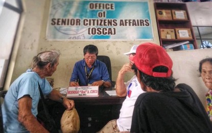 <p><strong>VALIDATION.</strong> Office of the Senior Citizens Affairs Tacloban head Rodrigo Cinco issues identification cards and booklets to senior citizens. The OSCA will revalidate qualification of elderlies who are beneficiaries of the government’s social pension program. <em>(Photo courtesy of OSCA Tacloban)</em></p>