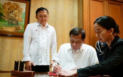 <p><strong>PAY HIKE.</strong> President Rodrigo Duterte on Wednesday (Jan. 8) signs the Salary Standardization Law 5 at Malacañan Palace. The new law implements the fifth round of salary increases for government workers. <em>(Presidential Photo by King Rodriguez)</em></p>