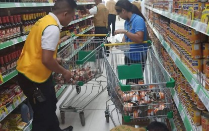 <p><strong>PULLED OUT.</strong> Personnel of the Provincial Veterinary Office (PVO) under the Provincial African Swine Fever (ASF) Task Force of Negros Occidental pull out canned goods such as pork and beans, and meatloaf from the shelves of a supermarket in La Castellana, Negros Occidental on Wednesday (Jan. 8, 2020). The items, which have been sourced from Luzon-based manufacturers, will be returned by the establishment to its distributors. (Photo courtesy of Provincial ASF Task Force-Negros Occidental)</p>