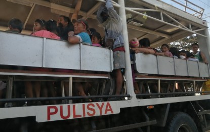 <p><strong>EVACUATION.</strong> Residents of towns located within Taal Volcano's 14-km. danger zone are evacuated to safer grounds on board a police truck. The DILG reported that about 98 percent of the residents in the danger zones have been evacuated as Taal Volcano is still on Alert Level 4. <em>(PNA photo by Lade Kabagani)</em></p>