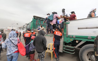 <p><strong>EVACUATION.</strong> Bureau of Fire Protection (BFP) personnel assist residents of Lemery, Batangas affected by the eruption of Taal Volcano as they move to safer grounds on Monday (Jan. 13, 2020). To avoid hazards caused by ashfall, the Department of Health (DOH) is advising the public to remain indoors and keep all windows and doors closed. <em>(PNA photo by Joey Razon)</em></p>