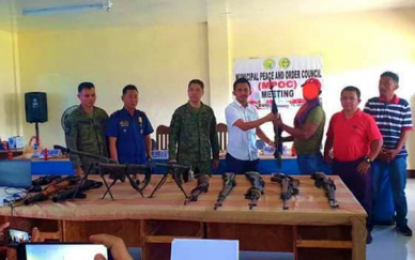 <p><strong>PEACEFUL LIFE AHEAD</strong>. A member of the Bangsamoro Islamic Freedom Fighters hands over his rifle to Mayor Allan Datu Angas Sr. (in white polo) of Sultan sa Barongis, Maguindanao, as Army officials, led by 601st Brigade commander Colonel Jose Narciso, look on. The BIFF surrenderer is a part of the 12-man group who yielded to military authorities on Tuesday (Jan. 14, 2020), citing exhaustion following intense military operations in the province. <em>(Photo courtesy of Mayor Allan Datu Angas, Sr.)</em></p>