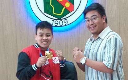 <p><strong>OLYMPICS IT IS</strong>. World boxing champion and Southeast Asian Games gold medalist Nesthy Petecio will lead two other University of Baguio students to the Asia-Oceania world qualifier in Wuhan, China starting February 3. Petecio poses with Baguio Sangguniang Kabataan chairman and councilor Levy Lloyd Orcales during a visit at the Baguio City mayor's office after winning the International Boxing Association title in October last year.<em> (PNA file photo by Pigeon Lobien)</em></p>