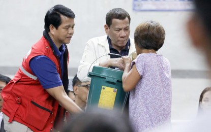 <p><strong>FOOD PACKS DISTRIBUTION.</strong>  President Rodrigo Roa Duterte leads the distribution of family food packs to residents affected by the Taal Volcano eruption, during his visit, at the Batangas City Sports Coliseum on Tuesday (Jan. 14, 2020). Malacañang on Thursday said Duterte is satisfied with the warnings issued by the Philippine Institute of Volcanology and Seismology (Phivolcs) about Taal Volcano’s activity. <em>(Presidential photo by Toto Lozano)</em></p>