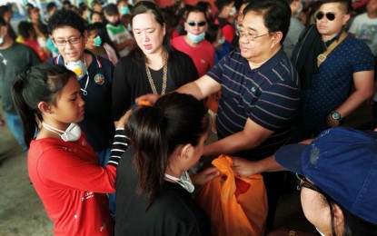 <p><strong>DAR AIDS TAAL VICTIMS</strong>. DAR Secretary John Castriciones and Eton International School president Jacqueline Tolentino (wearing black long sleeves) distribute relief goods to families affected by the eruption of Taal Volcano. The agency vowed to keep the help pouring in for the victims, especially the farmers and fisherfolk who lost their livelihood. <em>(Photo courtesy of DAR)</em></p>