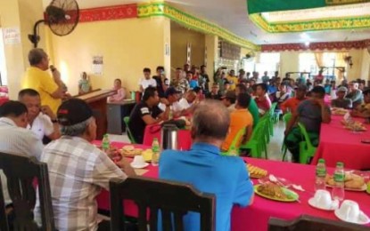 <p><strong>CONFLICT SETTLED.</strong> Mayor Yacob Ampatuan (standing, in yellow shirt) of Rajah Buayan, Maguindanao, lauds the warring families for acceding to the local government call and the military’s diplomatic intervention to settle their feud. The settlement aims to bring peace in their families and their town. <em>(Photo courtesy of Rajah Buayan LGU)</em></p>