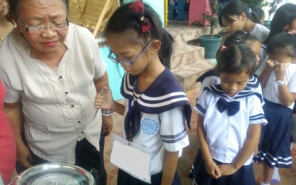 <p><strong>WEIGHT CHECK.</strong> A teacher checks the weight of one of her learners in Carigara, Leyte. The National Nutrition Council has called on parents to cooperate and submit their 0-59-month old children in the annual Operation Timbang (weighing) Plus. <em>(PNA photo by Sarwell Meniano)</em></p>
