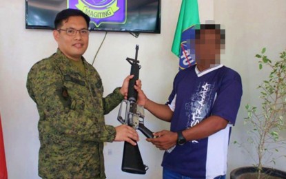 <p><strong>REBEL NO MORE.</strong> A former member of the Islamic State-inspired Bangsamoro Islamic Freedom Fighters (right) hands over his rifle to Lt. Col. Rogelio Gabi, commander of the Army’s 40th Infantry Battalion, during a surrender ceremony on Friday (Jan. 24, 2020). The surrenderer, identified only as a certain Malik for security reasons, pledged never to return to the extremist group.<em> (Photo courtesy of 40IB)</em></p>