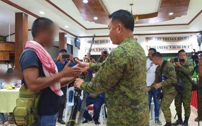 <p><strong>CEREMONIAL SURRENDER</strong>. Brigadier General Juvy Max Uy, Army’s 6th Infantry Division assistant commander (right), receives a rifle from one of the Bangsamoro Islamic Freedom Fighters members who opted to yield to military authorities in Maguindanao on Saturday (Jan. 25, 2020). The 12 former rebels earlier yielded to the Army’s 33rd and 40th Infantry Battalions before being brought to Camp Siongco, headquarters of the Army’s 6th Infantry Division, for their proper presentation and surrender. <em>(Photo courtesy of MILG–BARMM)</em></p>