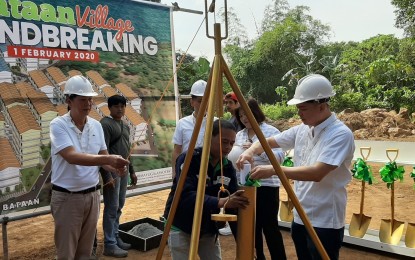 <p><strong>HOUSING PROJECT</strong>. Mayor Antonio Raymundo of Orion, Bataan holds the rope for the lowering of a time capsule while Governor Albert Garcia places a copy of a newspaper in a capsule as other officials watch during the groundbreaking ceremony for the construction of a permanent housing project for fire victims on Saturday (Feb. 1, 2020). A total of 1,089 families were rendered homeless by a fire in Sitio Depensa, Barangay Capunitan of the town last January 29. <em>(Photo by Ernie Esconde)</em></p>