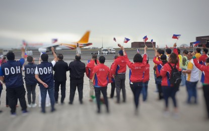 <p><strong>TOUCHED DOWN</strong>. Government officials wave Philippine flags as a chartered flight from Wuhan, China arrived at the Haribon Hangar in Clark Air Base iin Clark at around 7 a.m. on Sunday (Feb. 9, 2020). The repatriates, as well as the flight crew and the 10-man team who accompanied them, will undergo the prescribed 14-day quarantine in Tarlac. <em>(Photo courtesy of DFA)</em><br /><br /><br /></p>