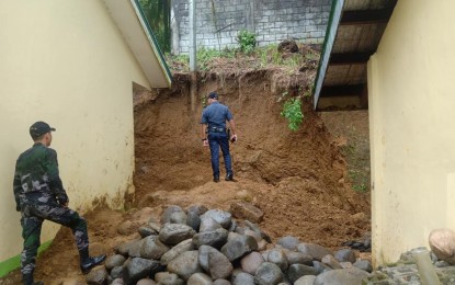 <p><strong>LANDSLIDE SITE.</strong> Policemen inspect the landslide site at Dan-an Elementary School in Pintuyan, Southern Leyte. Two laborers survived the landslide after their co-workers immediately rescued them on Thursday noon (Feb. 13, 2020).<em> (Photo courtesy of Pintuyan police station)</em></p>