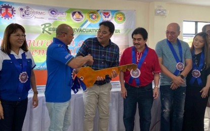 <p><strong>SYMBOLIC KEY.</strong> Regional Directors Lea Delfinado (left) of the Department of Public Works and Highways and Jose Roberto Nuñez (2nd from left), of the Office of Civil Defense in Western Visayas, lead the turn-over of the symbolic key of the Regional Evacuation Center in Bacolod City to Lone District Representative Greg Gasataya (3rd from left) and Mayor Evelio Leonardia (4th from left) in rites held on Friday (Feb. 14, 2020). The PHP33.7-million facility can accommodate at least 300 evacuees.<em> (Photo courtesy of Office of Civil Defense-Western Visayas)</em></p>