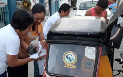 <p><strong>BIRTH IN TRANSIT</strong>. Two police officers of the Natividad Police Station in Pangasinan hold the newborn baby of a woman, whom they helped give birth while inside a tricycle on Valentine's Day. The mother was on the way to the Rural Health Unit, some four kilometers away from their home, when the baby came out on Friday (Feb. 14, 2020). <em>(Photo courtesy of Natividad Police Station)</em></p>