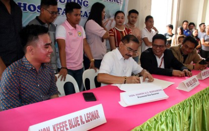 <p><strong>AID TO SK OFFICIALS.</strong> Agusan del Norte Governor Dale B. Corvera (seated, 2nd from left) signs on Monday (Feb. 17, 2020) the ordinance that would  grant hospitalization assistance to officials of the Sangguniang Kabataan in the province. The signing was witnessed by hundreds of SK officials, led by SK Provincial Federation president Keefe Blue R. Leonar (seated, left) and Provincial Administrator Gerry Joey Laurito (seated, 3rd from left). <em>(PNA photo by Alexander Lopez)</em></p>