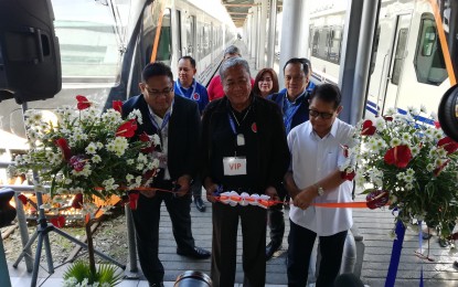 <p><strong>NEW TRAINS</strong>. Department of Transportation Secretary Arthur Tugade (center) Philippine National Railways (PNR) general manager Junn Magno (left), and other officials cut the inaugural ribbon during the send-off ceremony of the PNR's two new diesel multiple unit trains. Magno said the two new trains will ply the Tutuban-Alabang route, adding about 20,000 daily passenger capacity and shortening the route's headway to only 20 minutes. <em>(PNA photos by Raymond Carl Dela Cruz)</em></p>