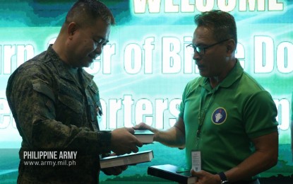 <p><strong>ARMED WITH 'THE GOSPEL'.</strong> Army chief-of-staff Brig. Gen. Rowen Tolentino (left) gets a Bible from Gideons International representative, retired Brig. Gen. Jose Johnriel Cenabre (right) during the turnover of Bible copies for the Philippine Army on Monday (Feb. 24, 2020). The Christian group has also been supplying free Bible copies to the Armed Forces of the Philippines to be placed inside military chapels and bases. <em>(Photo courtesy of Army Chief Public Affairs Office)</em></p>