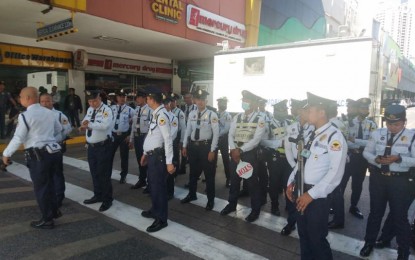 <p><strong>LOCKDOWN.</strong> Security guards at the V-Mall in Greenhills, San Juan receive last-minute instructions as the mall goes on lockdown due to an ongoing hostage-taking incident. Initial reports say some 30 people are being held hostage by a former security guard.<em> (PNA photo by Robert Oswald P. Alfiler)</em></p>
